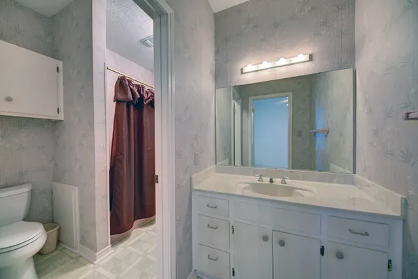 a bathroom with a toilet sink and mirror