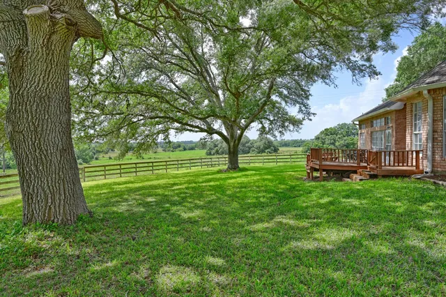a backyard of a house with barbeque oven table and chairs