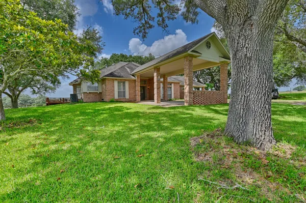a view of a house with a big yard and large tree