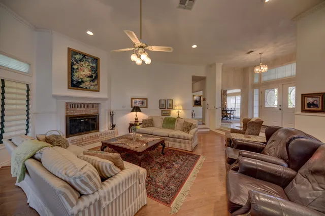 a living room with furniture a fireplace and a chandelier
