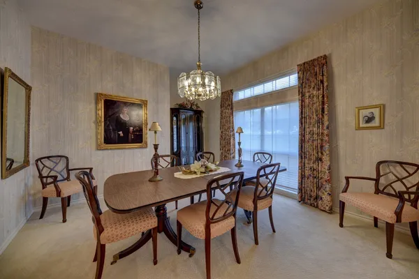 a dining room with furniture a chandelier and window