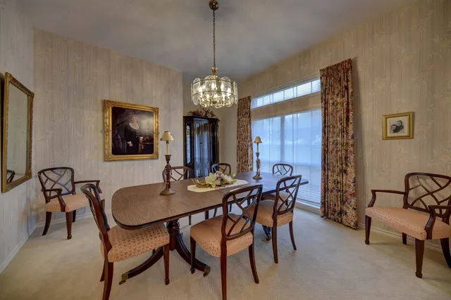 a dining room with furniture a chandelier and window