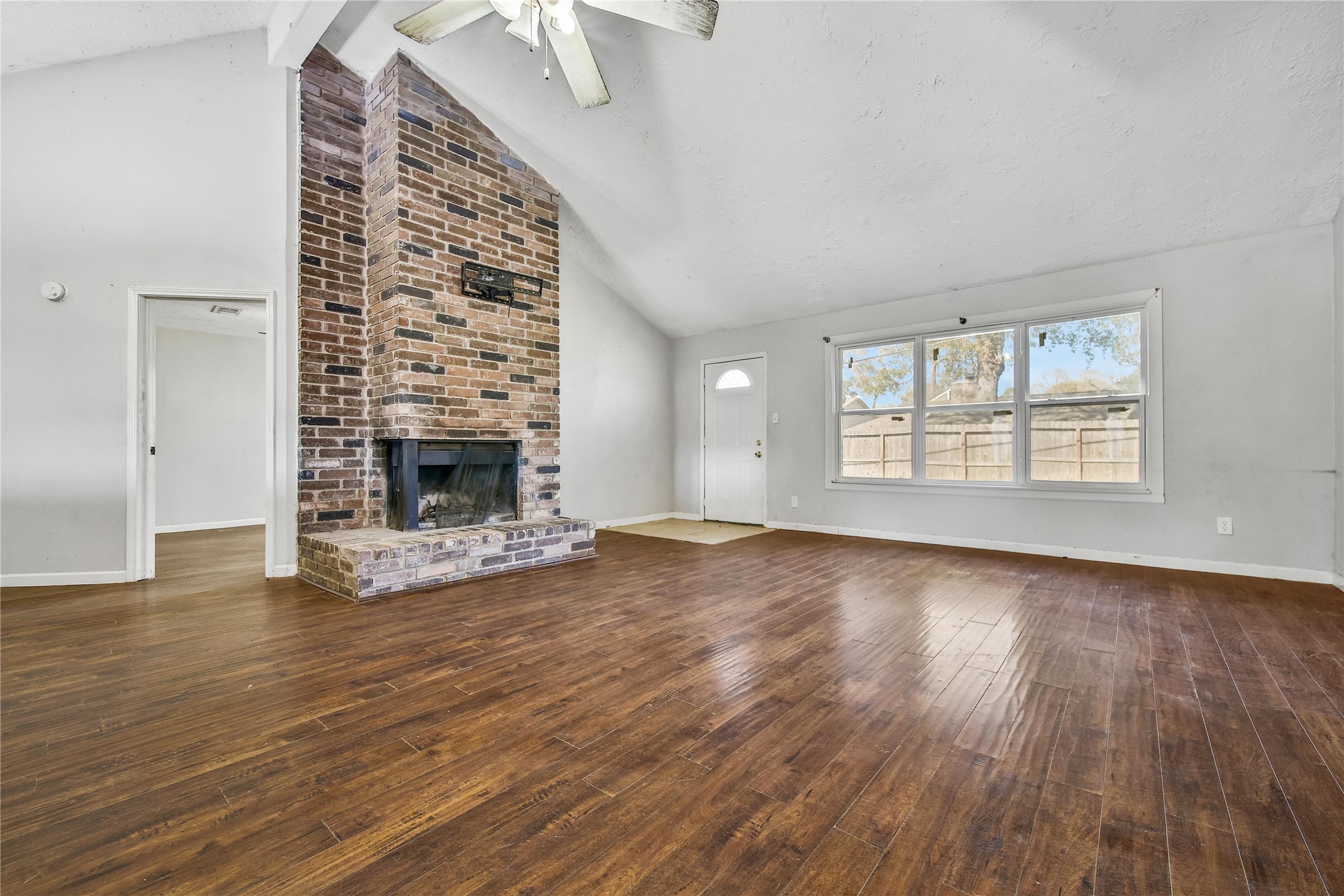 426 North Compass Rose Circle Crosby, TX 77532 - Photo 2 of 13 an empty room with wooden floor fireplace and windows