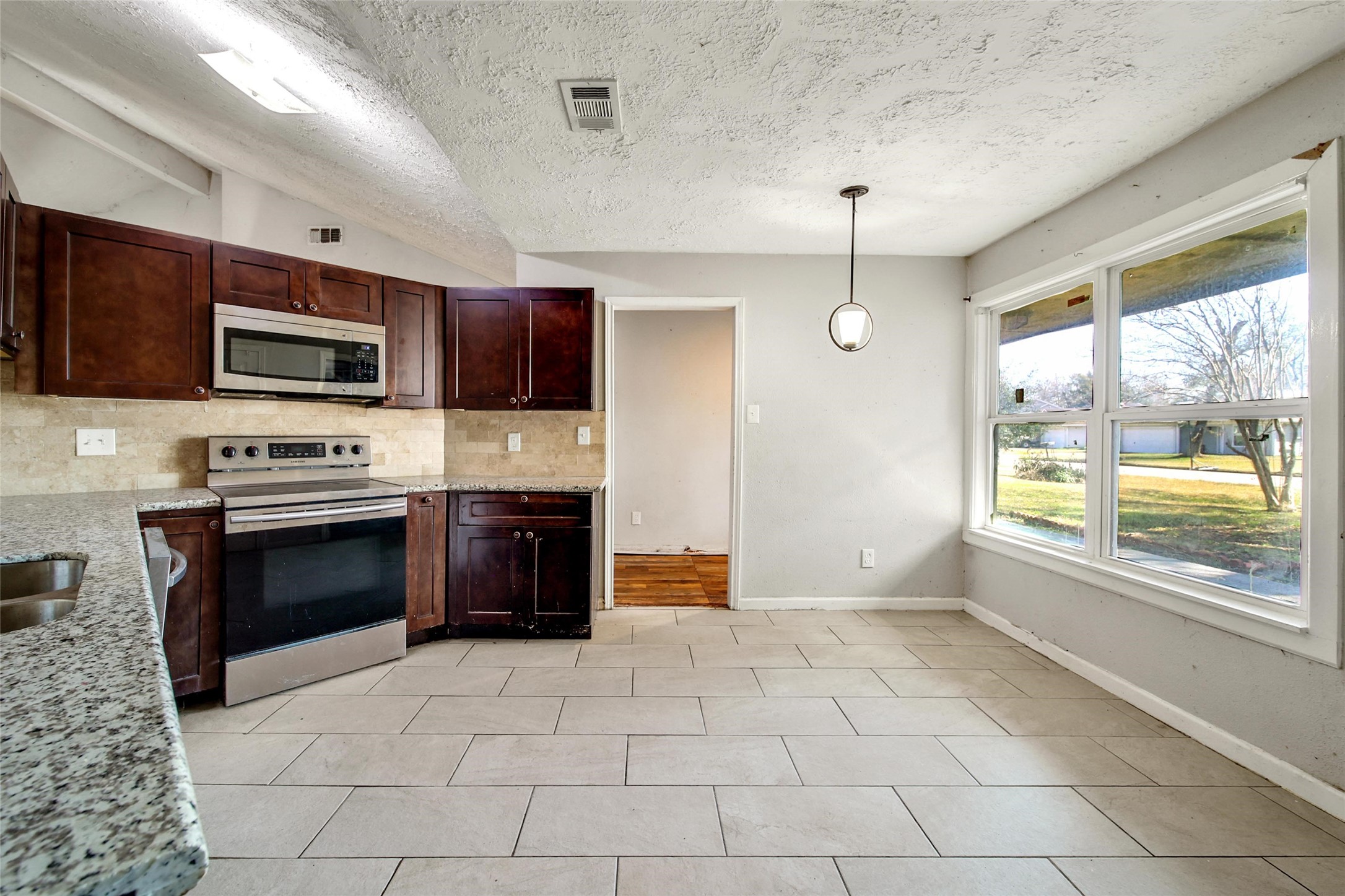 426 North Compass Rose Circle Crosby, TX 77532 - Photo 4 of 13 a kitchen with stainless steel appliances a stove a sink and a microwave