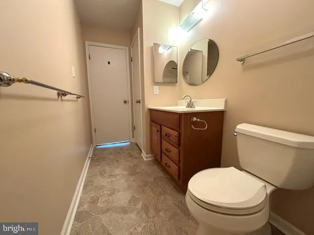 a bathroom with a toilet a sink and mirror
