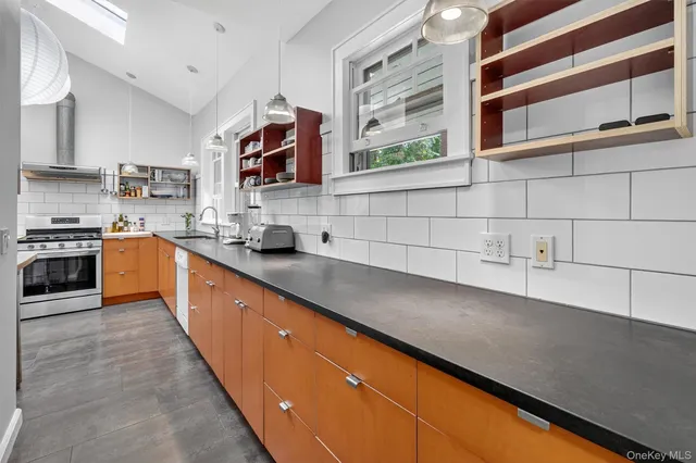 a large kitchen with stainless steel appliances wooden cabinets and a sink