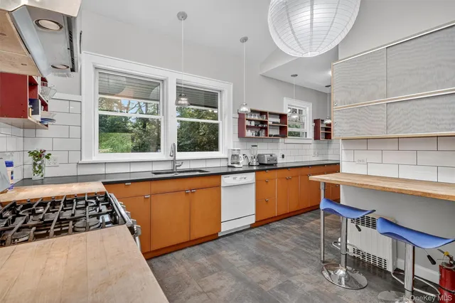 a kitchen with stainless steel appliances granite countertop a stove a sink and a dining table view