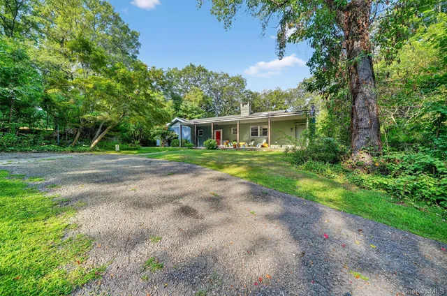 a view of a house with a yard and potted plants
