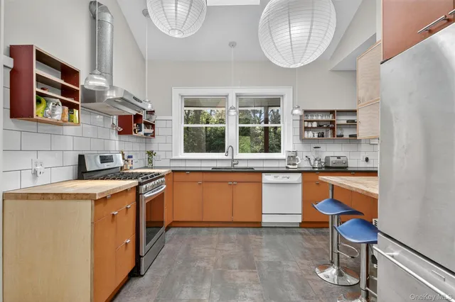 a kitchen with stainless steel appliances granite countertop a stove a sink and a refrigerator