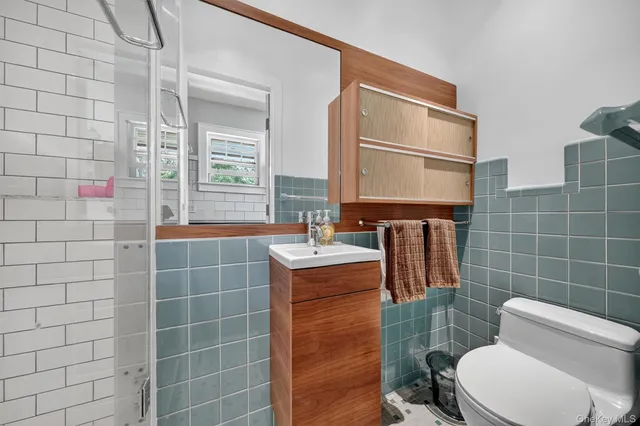 a bathroom with a toilet sink and mirror