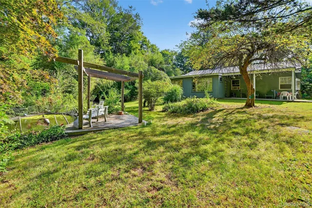 a view of a house with backyard and sitting area
