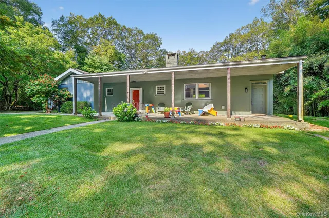 a view of a house with a yard and sitting area