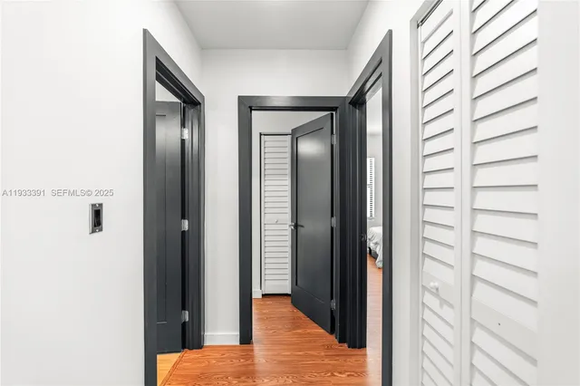 a view of a hallway with wooden floor and closet