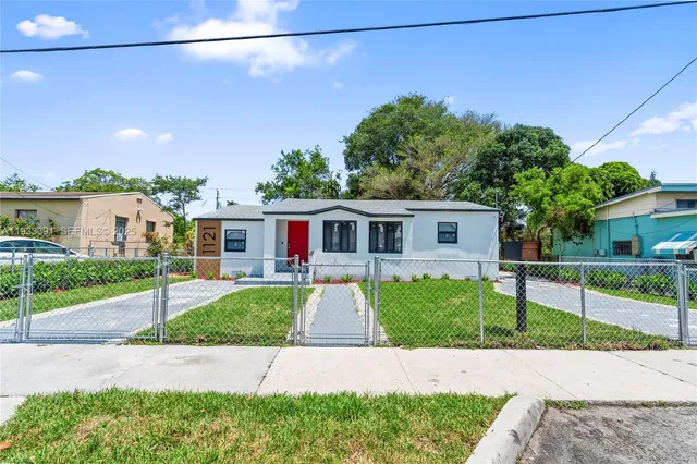 a front view of a house with a garden and trees