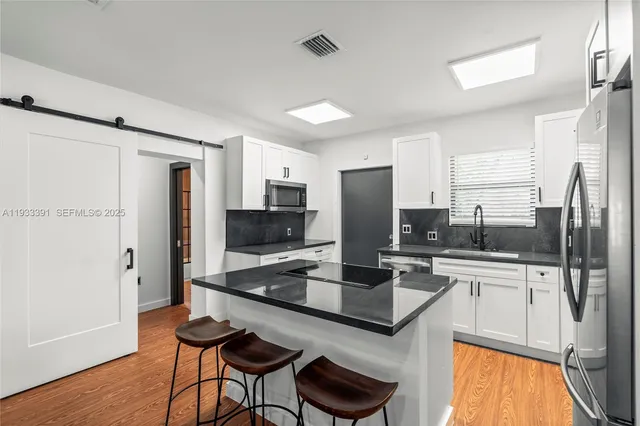 a kitchen with stainless steel appliances a refrigerator and a stove top oven