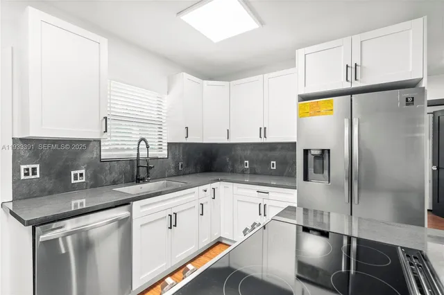 a kitchen with stainless steel appliances a sink a stove and a refrigerator