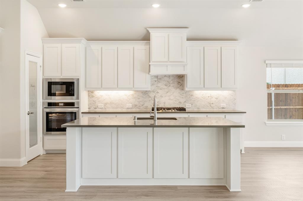 3512 Granite Rapids Road Mesquite, TX 75181 - Photo 13 of 40 a kitchen with granite countertop white cabinets and stainless steel appliances