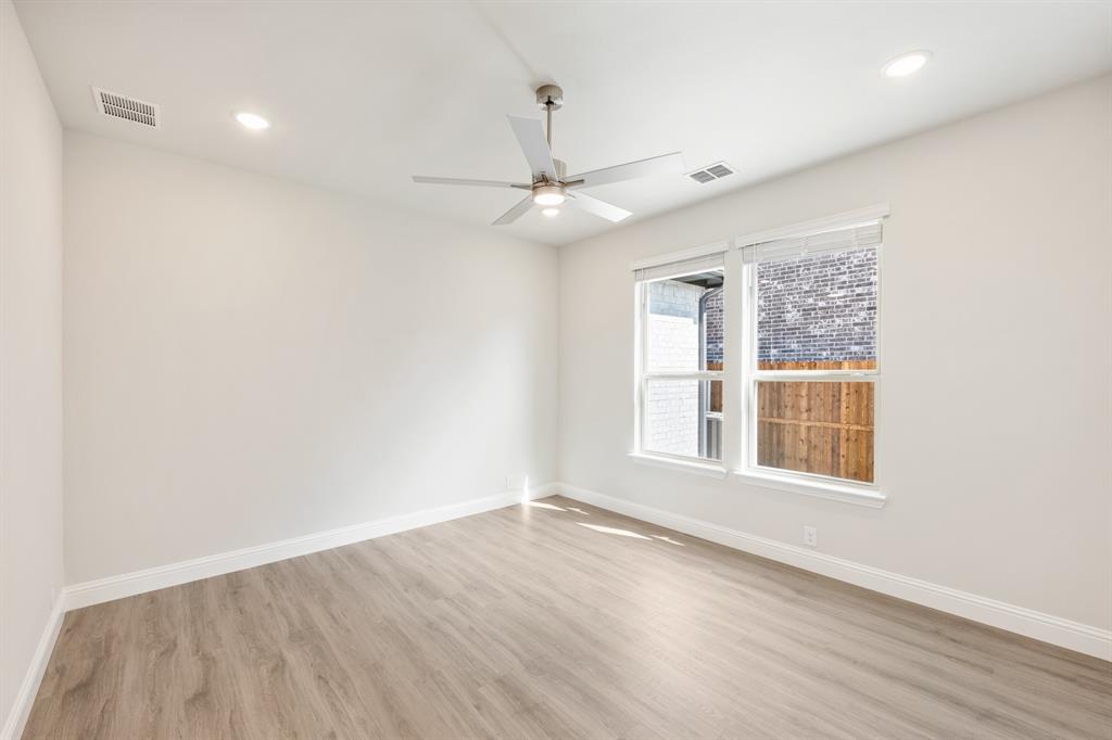 3512 Granite Rapids Road Mesquite, TX 75181 - Photo 18 of 40 an empty room with wooden floor ceiling fan and windows