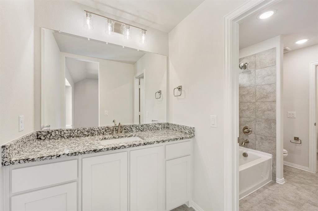 3512 Granite Rapids Road Mesquite, TX 75181 - Photo 33 of 40 a bathroom with a granite countertop sink and a mirror a bathtub