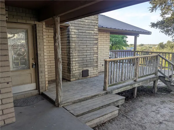 a view of a deck with a table and chair and wooden fence