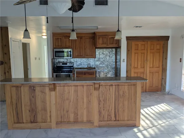 a kitchen with stainless steel appliances granite countertop a sink and a refrigerator