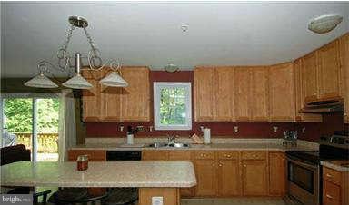 205 Captain Brendt Drive Accokeek, MD 20607 - Photo 12 of 28 a kitchen with granite countertop a sink a counter top space and cabinets