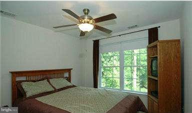 205 Captain Brendt Drive Accokeek, MD 20607 - Photo 14 of 28 a bedroom with a large bed and a chandelier
