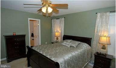 205 Captain Brendt Drive Accokeek, MD 20607 - Photo 17 of 28 a bedroom with a bed and a chandelier