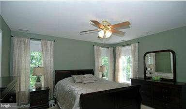 205 Captain Brendt Drive Accokeek, MD 20607 - Photo 18 of 28 a bedroom with a large bed and a chandelier