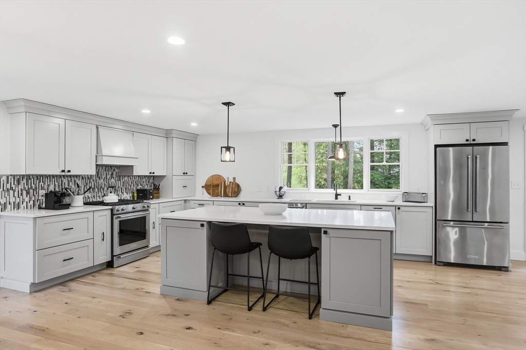 136 Holden Wood Road Concord, MA 01742 - Photo 9 of 31 a kitchen with stainless steel appliances granite countertop a table chairs sink refrigerator and cabinets