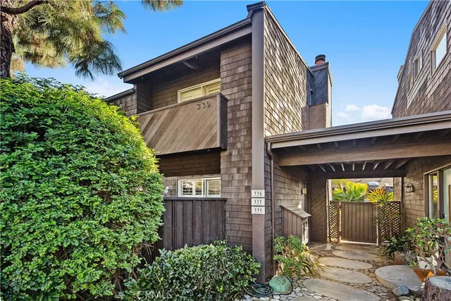 a view of a house with potted plants and a bench