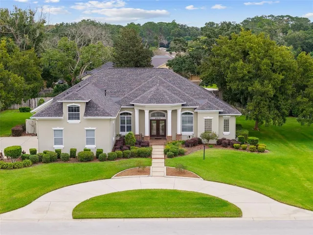 a front view of a house with a yard and trees