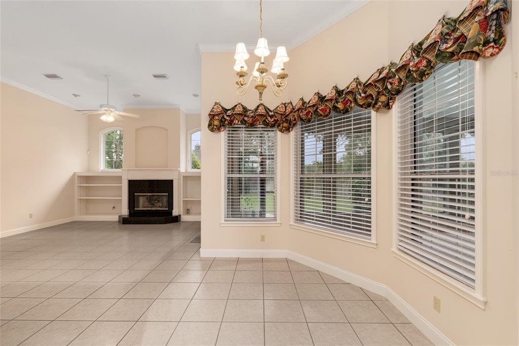 4815 Southeast 12th Place Ocala, FL 34471 - Photo 16 of 59 a view of a livingroom with a fireplace a chandelier and windows