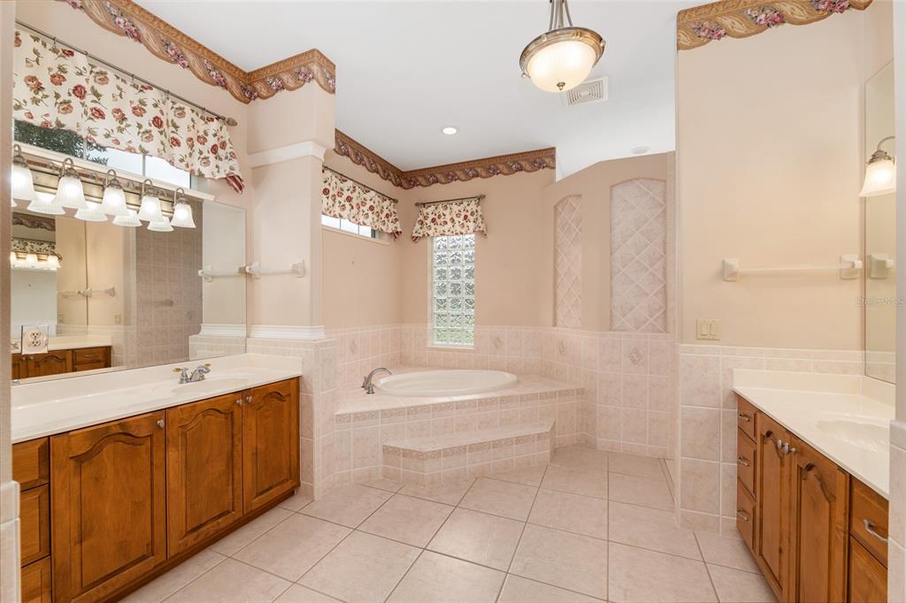 4815 Southeast 12th Place Ocala, FL 34471 - Photo 22 of 59 a spacious bathroom with a sink a toilet a mirror and bathtub