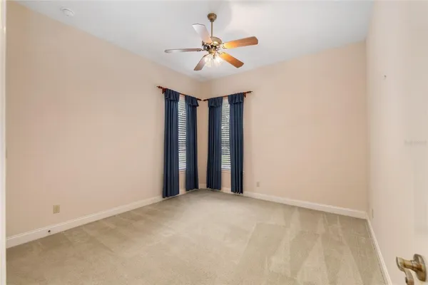 an empty room with a window and a ceiling fan