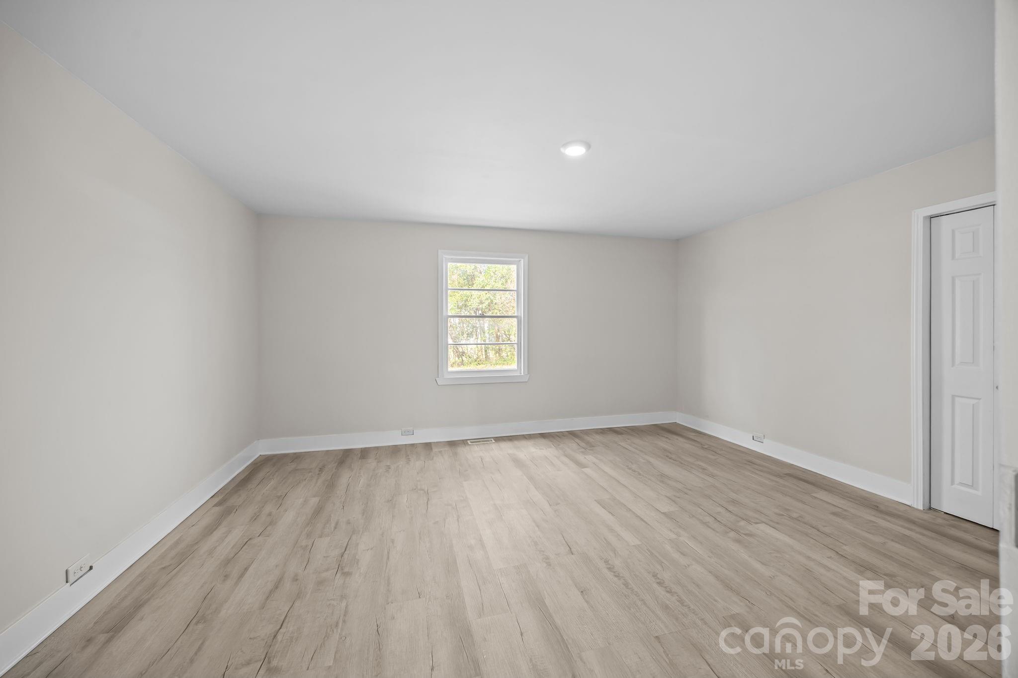 511 East Trade Street Dallas, NC 28034 - Photo 10 of 16 an empty room with wooden floor and window