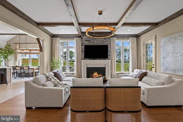 a living room with furniture a ceiling fan a fireplace and a large window