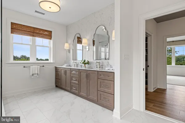 a spacious bathroom with a granite countertop sink a mirror and a bathtub