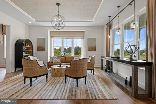 a living room with furniture a chandelier and wooden floor
