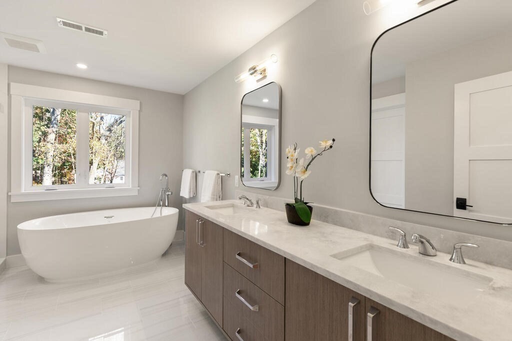 445 Lowell Street Lexington, MA 02420 - Photo 20 of 41 a bathroom with a double vanity sink a bathtub and a mirror