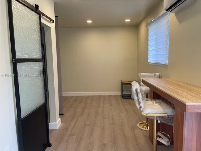 a kitchen with a refrigerator and a wooden floor