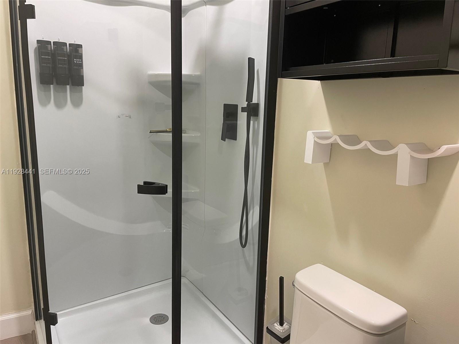 14121 Kendale Lakes Boulevard, Unit 14121 Miami, FL 33183 - Photo 7 of 9 a bathroom with a toilet and a shower