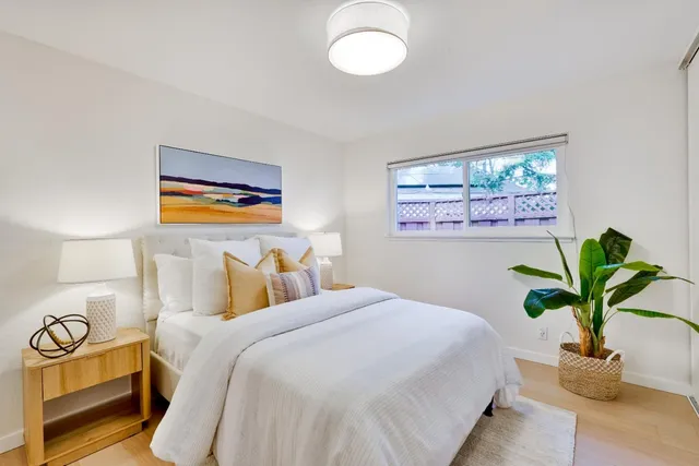 a bedroom with a bed and a potted plant