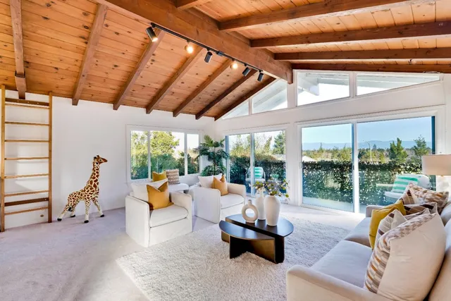 a living room with patio furniture and a large window