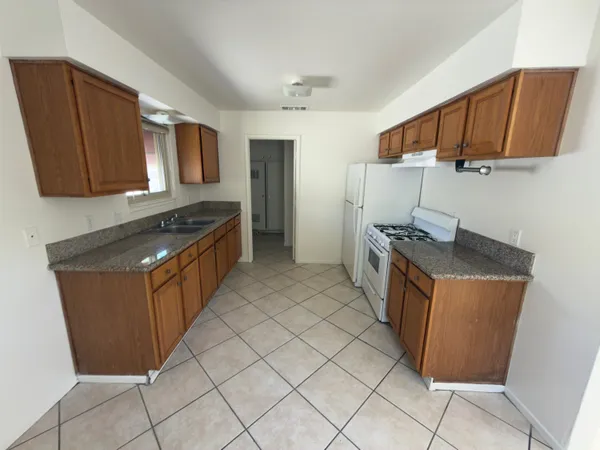 a kitchen with stainless steel appliances granite countertop a stove a sink and a refrigerator