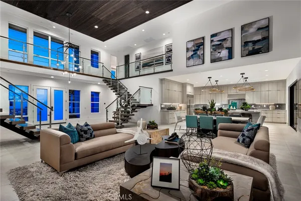 a living room with furniture kitchen view and a large window