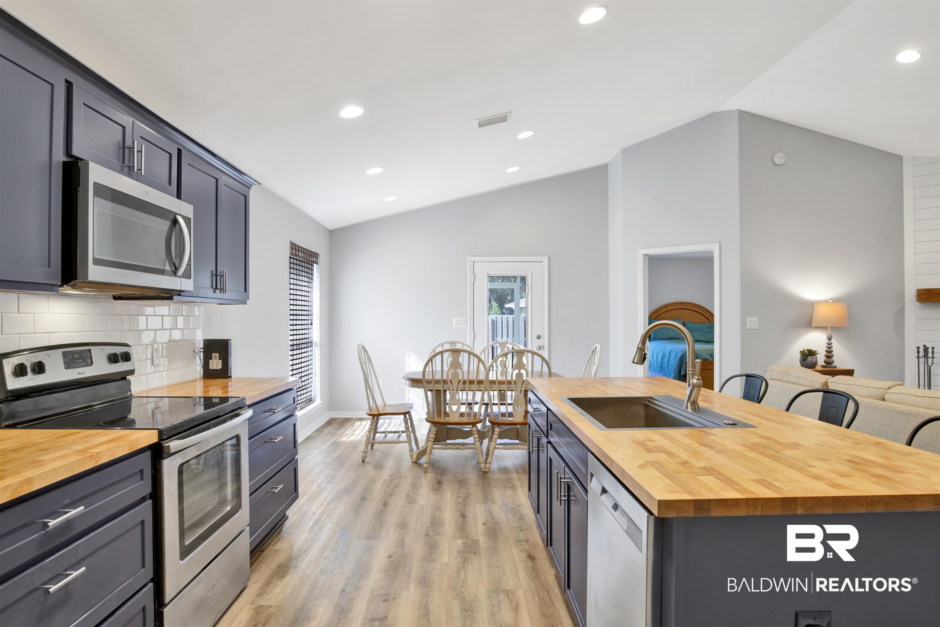 7145 Raintree Lane Gulf Shores, AL 36542 - Photo 9 of 25 Kitchen featuring butcher block countertops, stainless steel appliances, lofted ceiling, and sink