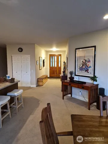 a living room with furniture kitchen area and a large window