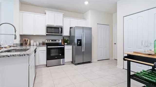 a kitchen with stainless steel appliances granite countertop a stove refrigerator and cabinets