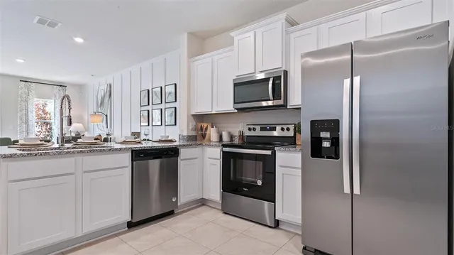 a kitchen with stainless steel appliances granite countertop a refrigerator and a sink